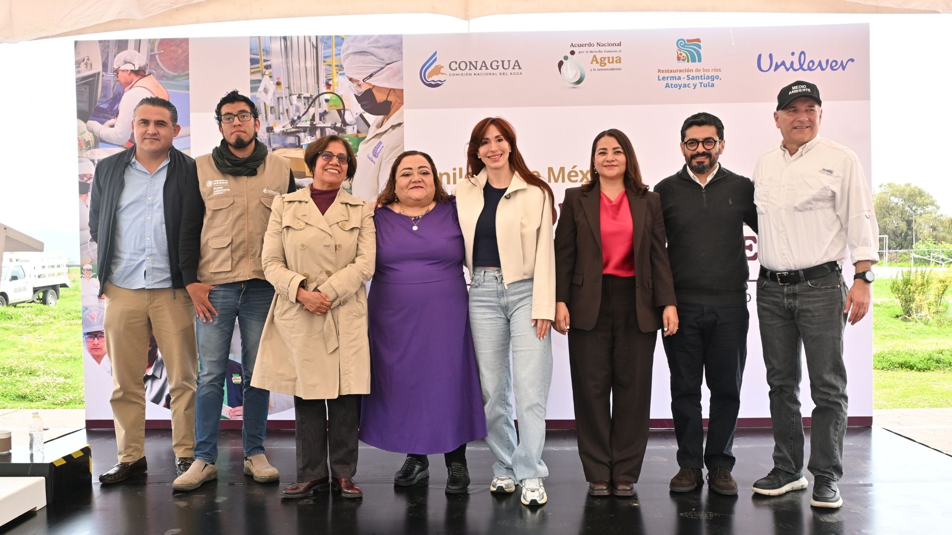 Ocho representantes posan juntos en un evento de colaboración para la restauración del agua en México.
